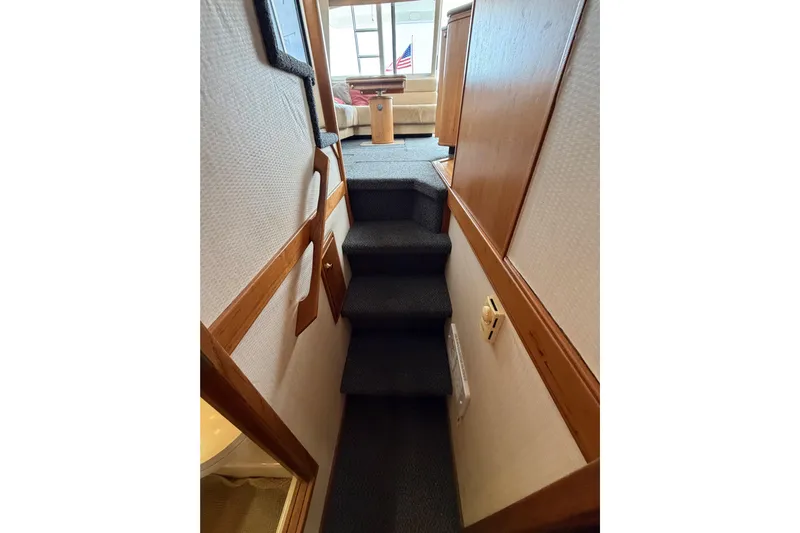B Liner Yacht Photos Pics Interior stairs of 1998 Bayliner 4788 Pilot House Motoryacht, leading to a cozy seating area.