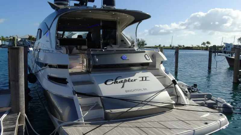 Chapter II Yacht Photos Pics 2023 Riviera 6000 Sport Yacht docked in a sunny marina.