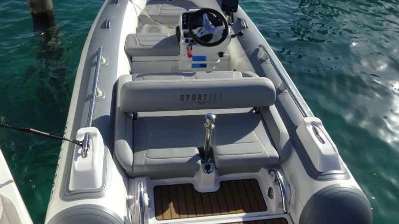 Chapter II Yacht Photos Pics 2023 Riviera 6000 Sport Yacht interior with steering wheel and seating on clear water.