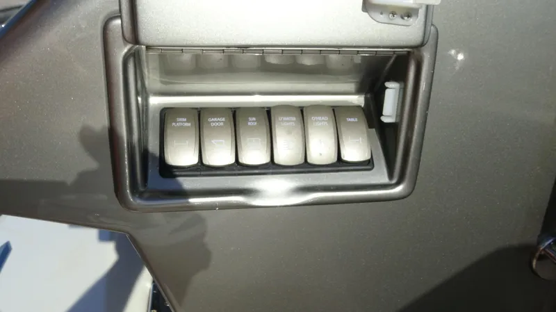 Chapter II Yacht Photos Pics Control panel of a 2023 Riviera 6000 Sport Yacht with labeled switches.