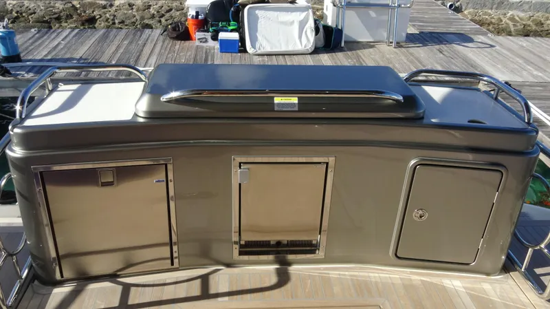 Chapter II Yacht Photos Pics 2023 Riviera 6000 Sport Yacht outdoor kitchen with stainless steel appliances on deck.