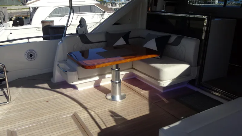 Chapter II Yacht Photos Pics 2023 Riviera 6000 Sport Yacht interior with elegant seating and wooden table.