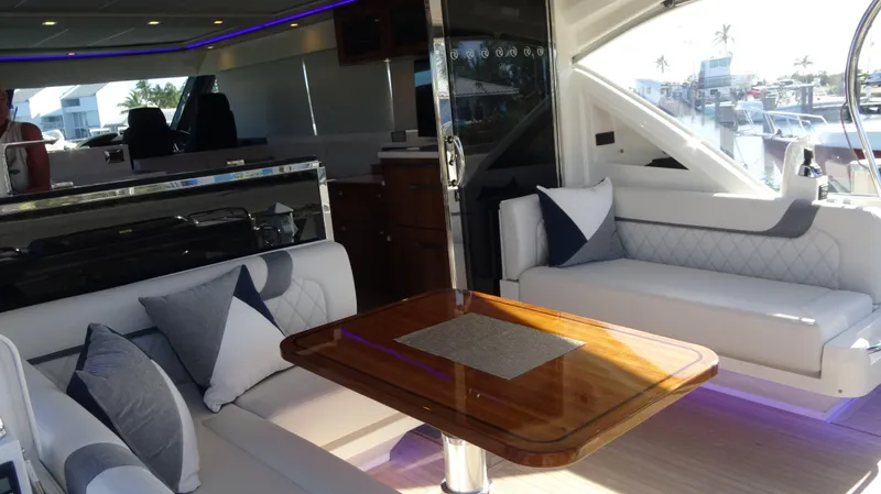 Chapter II Yacht Photos Pics Luxurious interior of 2023 Riviera 6000 Sport Yacht with elegant seating and wooden table.