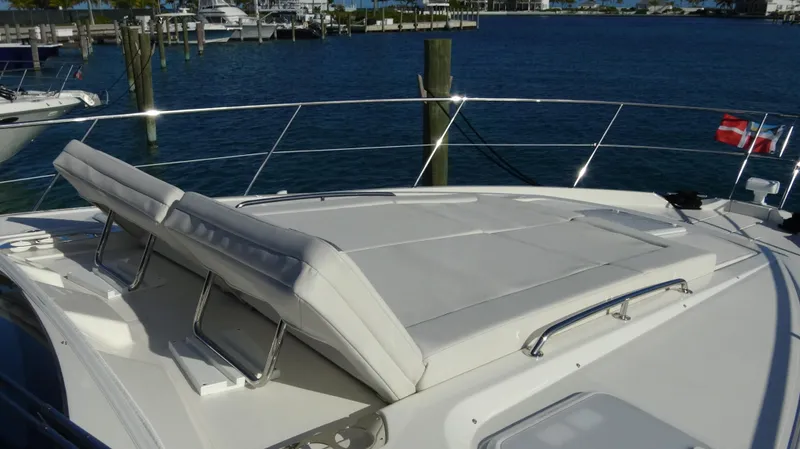 Chapter II Yacht Photos Pics 2023 Riviera 6000 Sport Yacht with sunbathing deck, docked at marina.