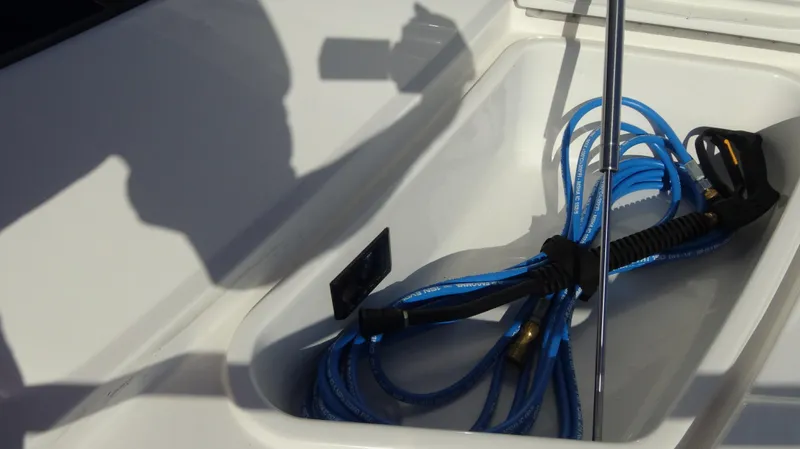 Chapter II Yacht Photos Pics Coiled blue hose in 2023 Riviera 6000 Sport Yacht compartment.