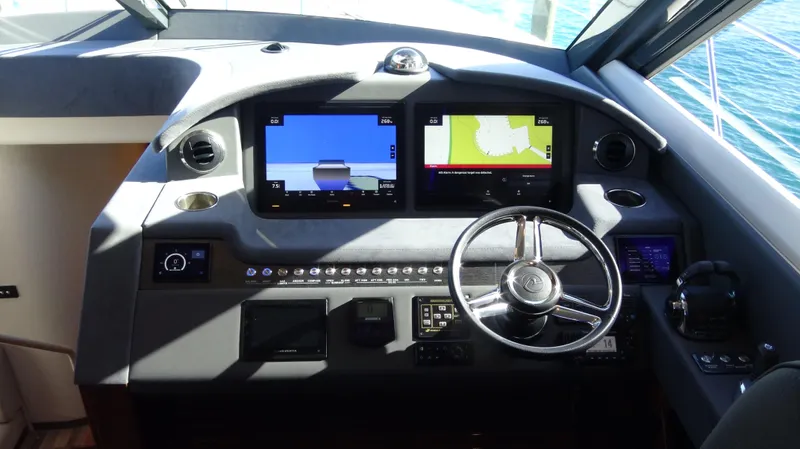 Chapter II Yacht Photos Pics 2023 Riviera 6000 Sport Yacht helm with dual navigation screens and modern controls.