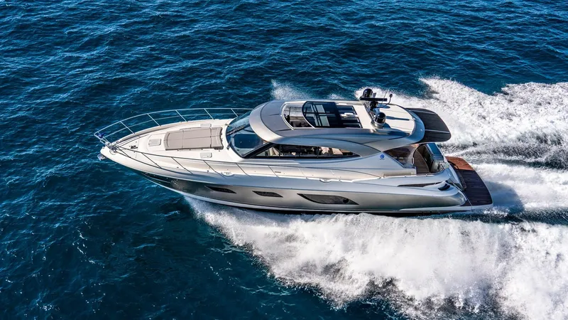 Chapter II Yacht Photos Pics 2023 Riviera 6000 Sport Yacht cruising on open water, showcasing sleek design and luxury.
