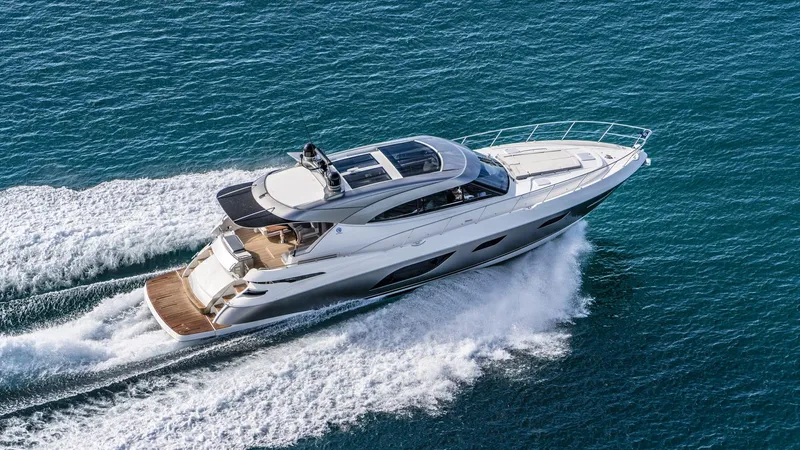 Chapter II Yacht Photos Pics 2023 Riviera 6000 Sport Yacht cruising on open water, showcasing sleek design and luxury.