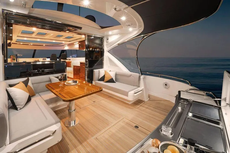 Chapter II Yacht Photos Pics 2023 Riviera 6000 Sport Yacht interior with elegant seating and ocean view.