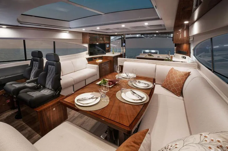 Chapter II Yacht Photos Pics Luxurious interior of 2023 Riviera 6000 Sport Yacht with elegant dining area and plush seating.
