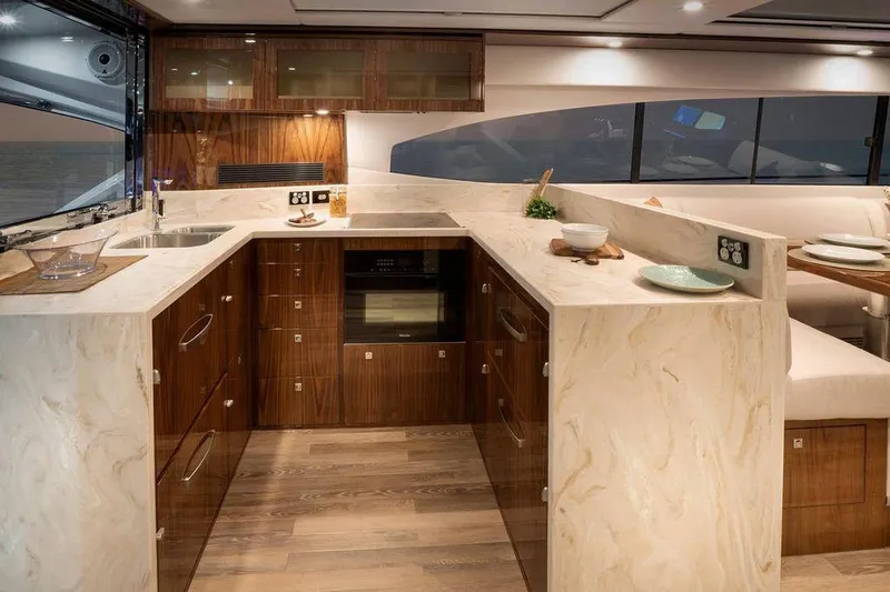 Chapter II Yacht Photos Pics Luxurious kitchen interior of 2023 Riviera 6000 Sport Yacht with modern amenities and elegant design.