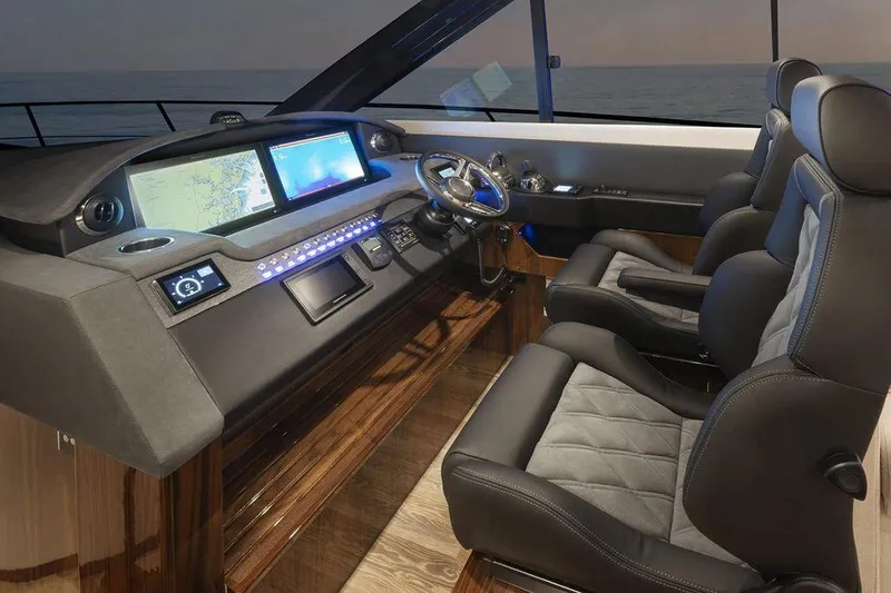 Chapter II Yacht Photos Pics 2023 Riviera 6000 Sport Yacht cockpit with modern navigation displays and luxurious seating.