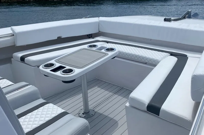 Hull 136 Yacht Photos Pics 2025 Hammer Yachts HammerCat 35 interior with white seating and table, docked by water.
