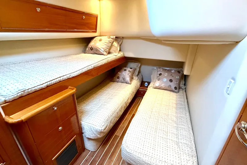 Golden Rule Yacht Photos Pics 2006 Riviera 42 Flybridge cabin with cozy twin beds and wooden cabinetry.