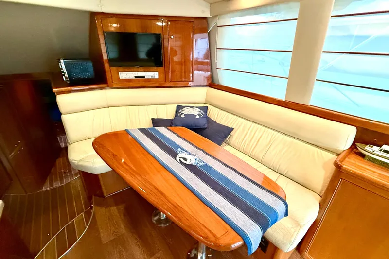 Golden Rule Yacht Photos Pics Luxurious interior of 2006 Riviera 42 Flybridge yacht with elegant seating and wooden table.