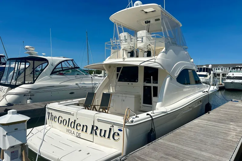 Golden Rule Yacht Photos Pics 2006 Riviera 42 Flybridge yacht docked at marina under clear blue sky.