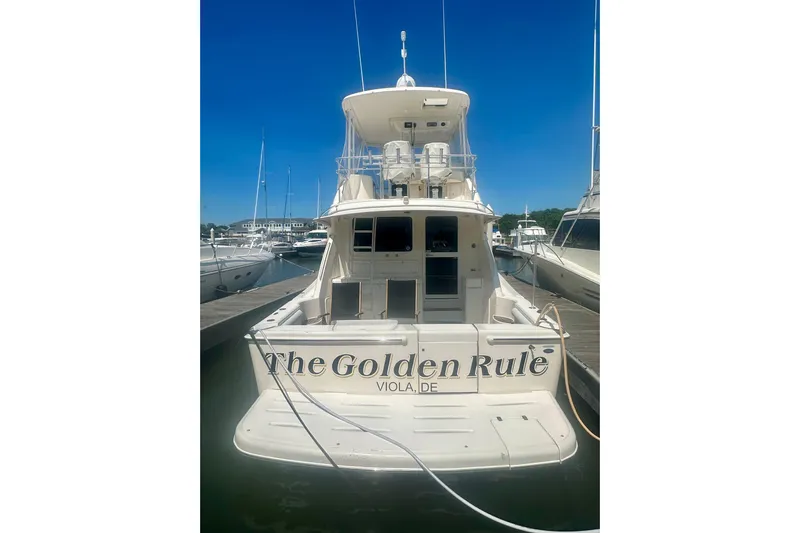 Golden Rule Yacht Photos Pics 2006 Riviera 42 Flybridge yacht docked, rear view with "The Golden Rule" name.