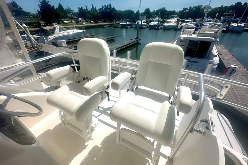 Golden Rule Yacht Photos Pics 2006 Riviera 42 Flybridge yacht with white captain chairs at marina.