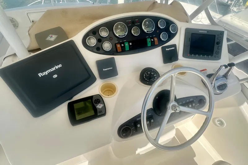 Golden Rule Yacht Photos Pics Helm of 2006 Riviera 42 Flybridge with Raymarine navigation equipment and steering wheel.