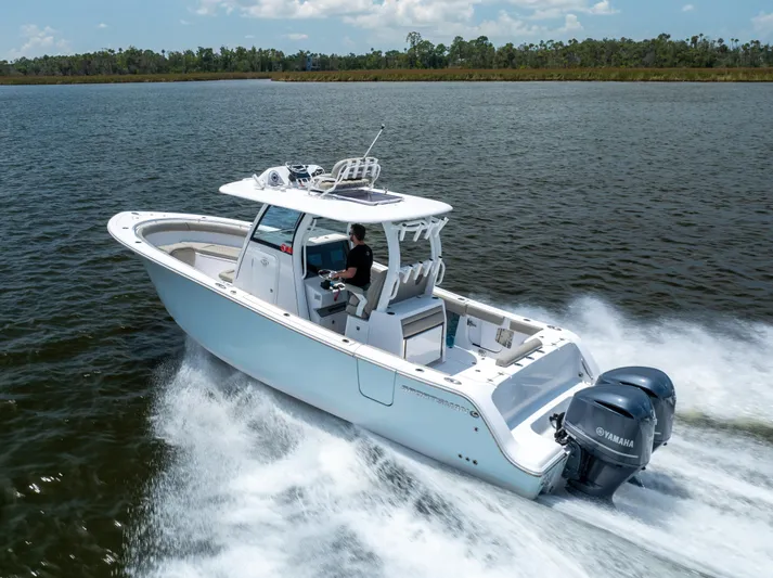  Yacht Photos Pics 2021 Sportsman Open 302 Center Console boat cruising on a lake.