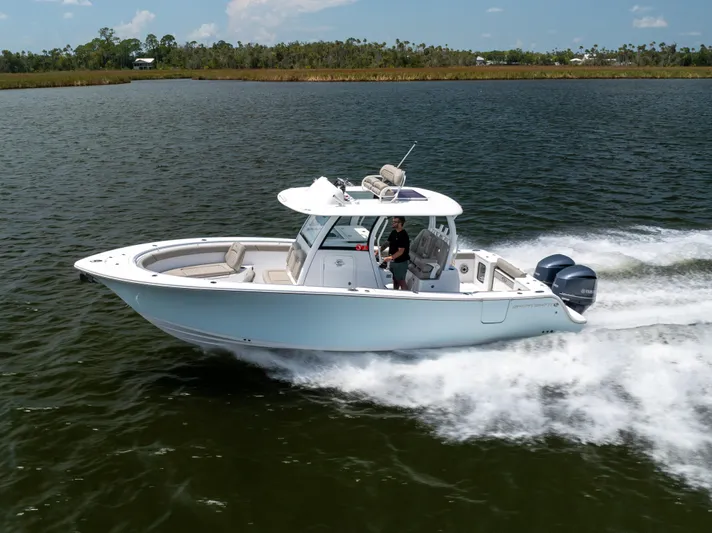  Yacht Photos Pics 2021 Sportsman Open 302 Center Console boat cruising on a lake.