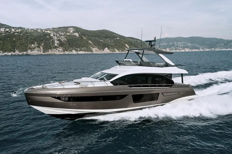  Yacht Photos Pics Azimut Fly 68 yacht cruising on the ocean, 2025 model, with scenic coastal backdrop.
