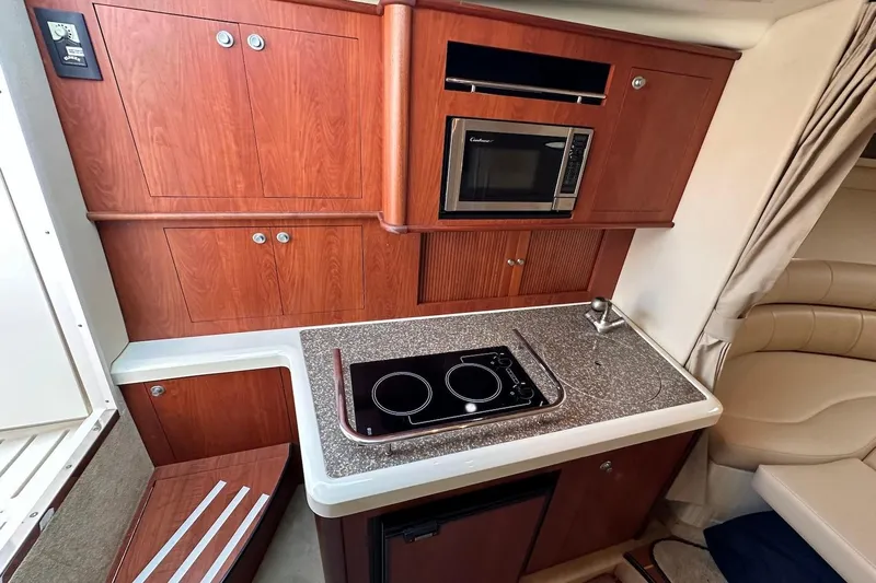 Key West Yacht Photos Pics 2011 Monterey 315 SCR yacht interior kitchen with microwave, stove, and wooden cabinetry.