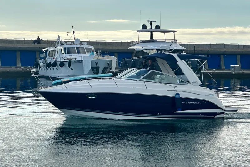 Key West Yacht Photos Pics 2011 Monterey 315 SCR boat docked in a marina, calm water, overcast sky.