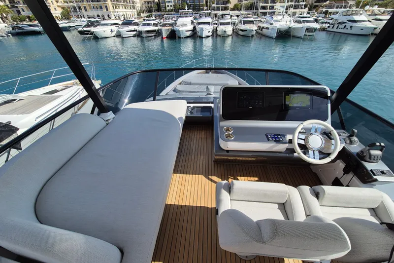  Yacht Photos Pics Luxurious 2023 Azimut Fly 68 yacht interior with helm, overlooking marina.