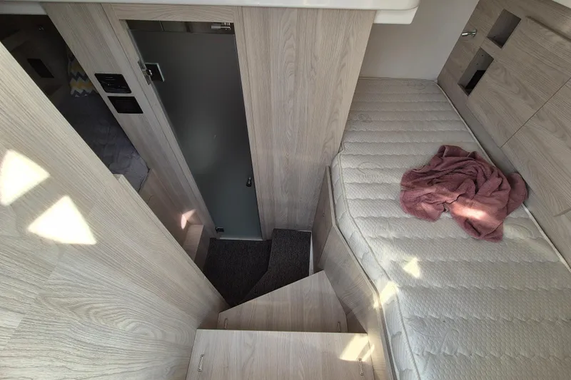  Yacht Photos Pics Interior of 2023 Azimut Fly 68 yacht with wooden stairs and cozy sleeping area.