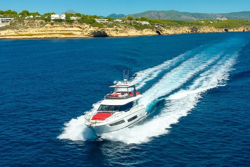  Yacht Photos Pics Luxury 2017 Prestige 680 yacht cruising on clear blue waters near scenic coastline.