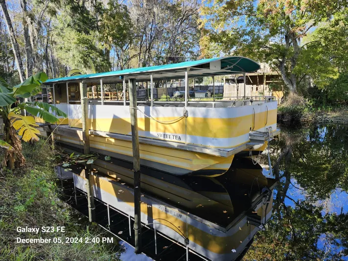 Sweet Tea Yacht Photos Pics Yellow and white 2016 Rover Marine Carolina Rover 40 boat docked on a serene river.