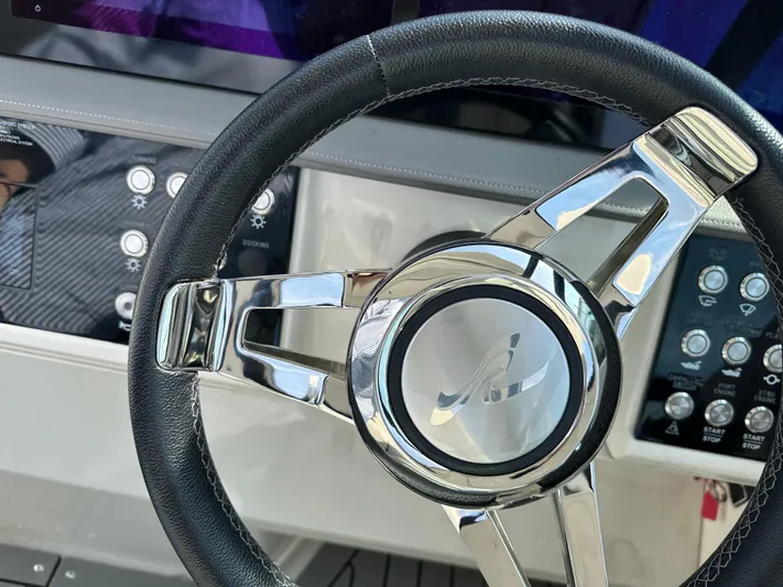  Yacht Photos Pics Steering wheel of a 2020 Sea Ray Sundancer 320 boat, featuring modern controls.