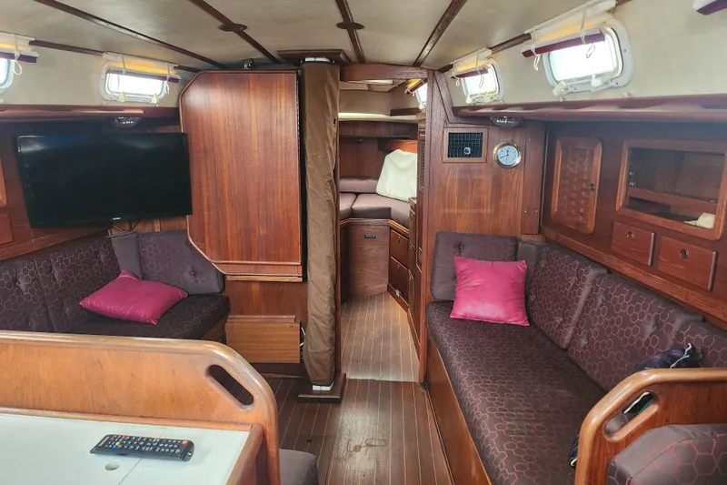 Isola Bella Yacht Photos Pics Interior of 1988 Sabre 42 yacht with wood finish, seating, and TV.