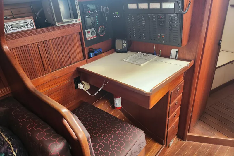 Isola Bella Yacht Photos Pics Navigation station in a 1988 Sabre 42 sailboat with wooden interior and control panel.