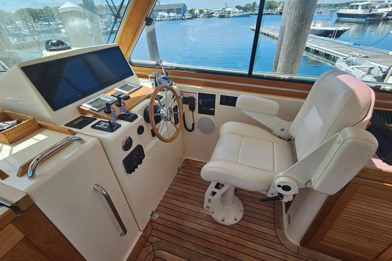  Yacht Photos Pics 2009 Sabre 42 Express helm with steering wheel, controls, and white captain's chair.