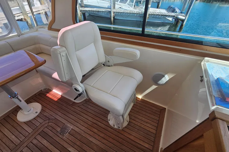  Yacht Photos Pics 2009 Sabre 42 Express yacht interior with white captain's chair and wooden flooring.