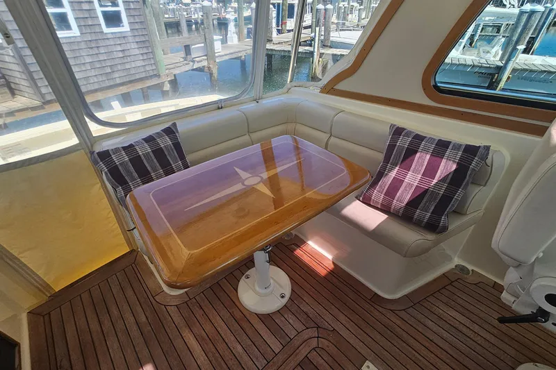  Yacht Photos Pics Interior of 2009 Sabre 42 Express yacht with wooden table and plaid cushions.