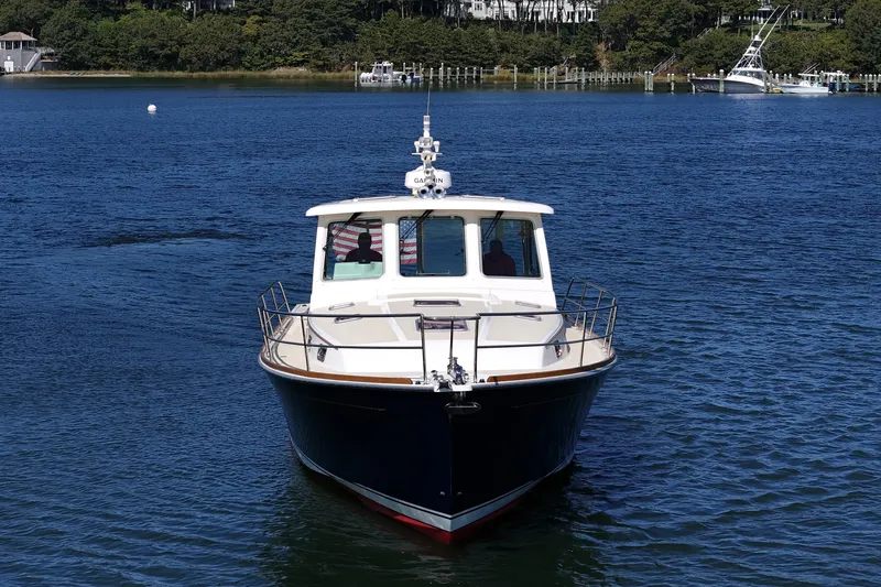  Yacht Photos Pics 2009 Sabre 42 Express boat on calm water, surrounded by lush greenery.