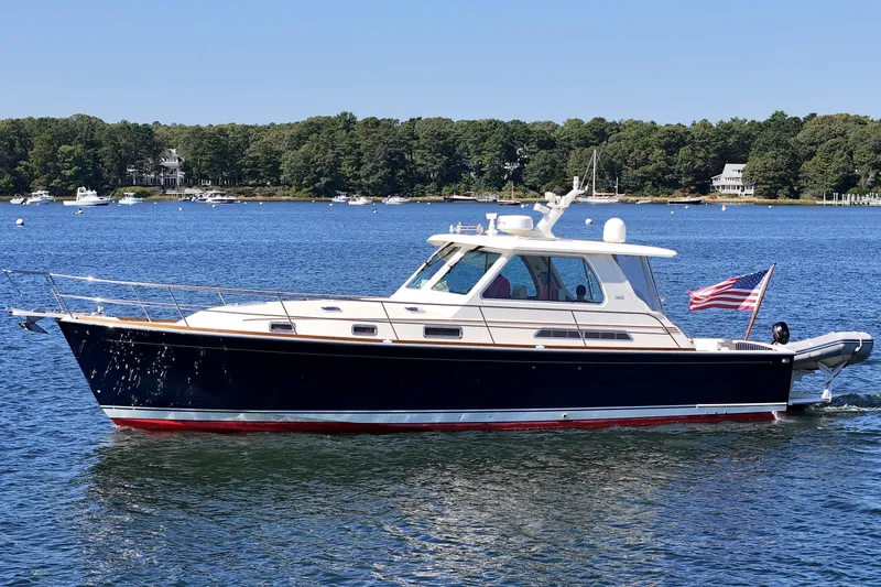  Yacht Photos Pics 2009 Sabre 42 Express yacht cruising on a serene lake with forested shoreline.