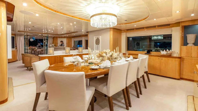 Stay Salty Yacht Photos Pics Luxurious dining area on 2010 Horizon Premier 135 yacht, featuring elegant decor and chandelier.