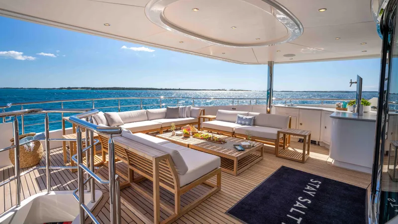 Stay Salty Yacht Photos Pics Luxurious Horizon Premier 135 yacht deck with elegant seating, ocean view, and sunny ambiance.