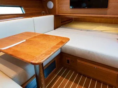Call For Availability Yacht Photos Pics Interior of 2025 Sabre 43 Salon Express yacht with wooden table and white seating.