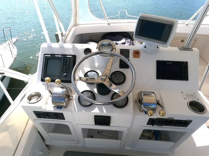  Yacht Photos Pics 2002 Luhrs 34 Convertible boat helm with navigation equipment and steering wheel.