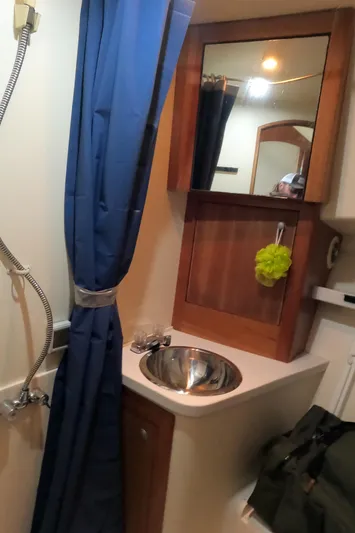  Yacht Photos Pics 2002 Luhrs 34 Convertible bathroom with sink, mirror, and shower curtain.