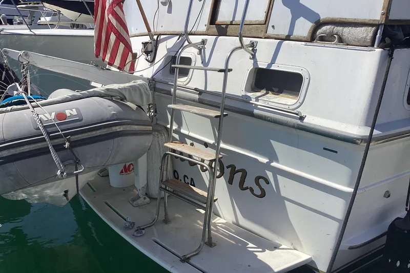 No Reservations Yacht Photos Pics 1984 Spindrift 52 Motor Yacht with dinghy and American flag at dock.