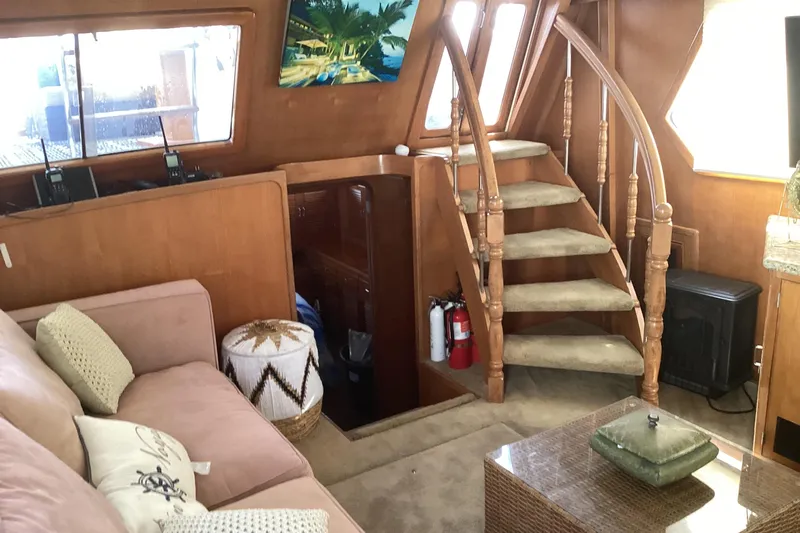 No Reservations Yacht Photos Pics Interior of 1984 Spindrift 52 Motor Yacht with cozy seating and elegant staircase.