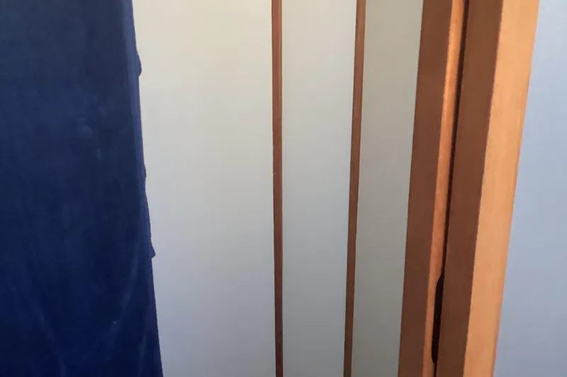 No Reservations Yacht Photos Pics Interior view of 1984 Spindrift 52 Motor Yacht with wooden paneling and blue fabric.