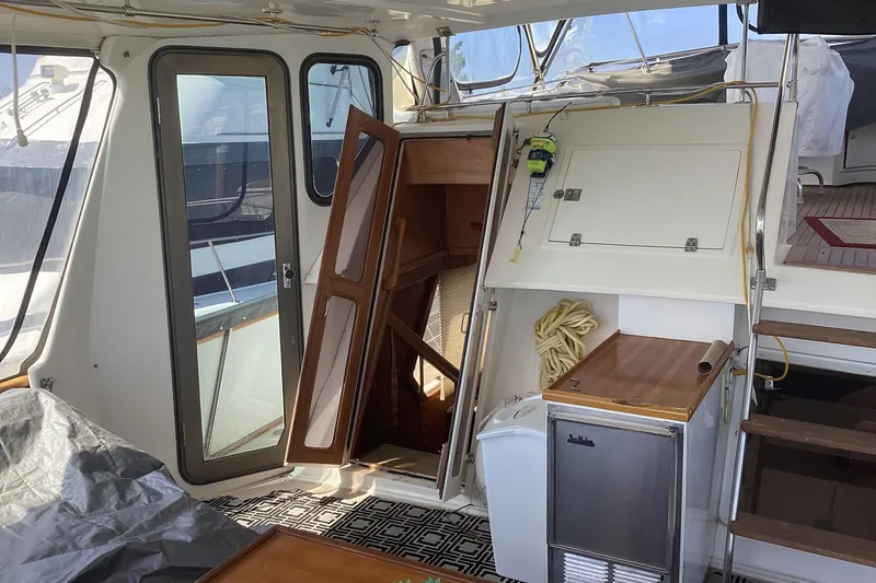 No Reservations Yacht Photos Pics 1984 Spindrift 52 Motor Yacht interior with wooden stairs, door, and compact kitchenette.