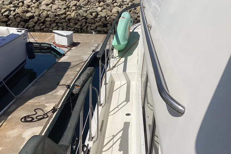 No Reservations Yacht Photos Pics 1984 Spindrift 52 Motor Yacht docked, showing side deck and railing.